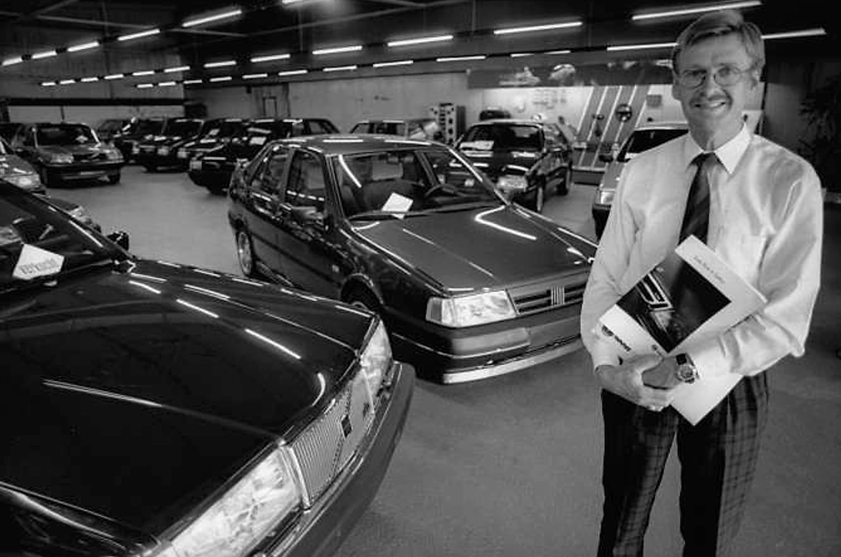 Peter Commandeur in de showroom van de garage, tussen de Volvo's en Fiats